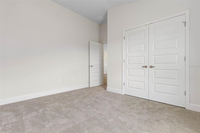 unfurnished bedroom with a closet, carpet, and baseboards