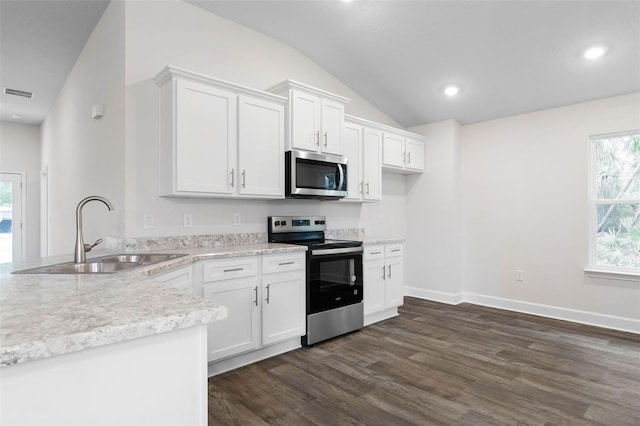 25 Port Echo Ln, Palm Coast, FL 32164 - kitchen with stainless steel appliances, dark wood-style flooring, lofted ceiling, a peninsula, and white cabinets