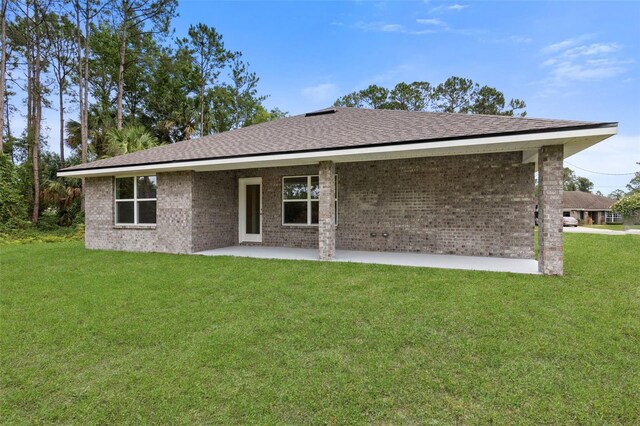 25 Port Echo Ln, Palm Coast, FL 32164 - back of property with a patio area, a yard, brick siding, and roof with shingles