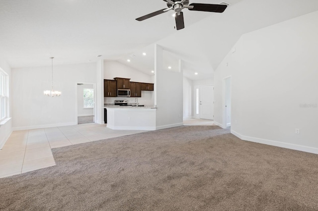 unfurnished living room featuring light tile patterned flooring, ceiling fan with notable chandelier, and high vaulted ceiling