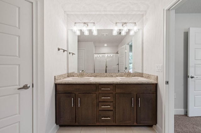 bathroom featuring vanity, a shower with shower door, and tile patterned flooring