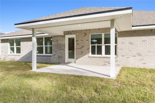 rear view of house featuring a lawn and a patio area