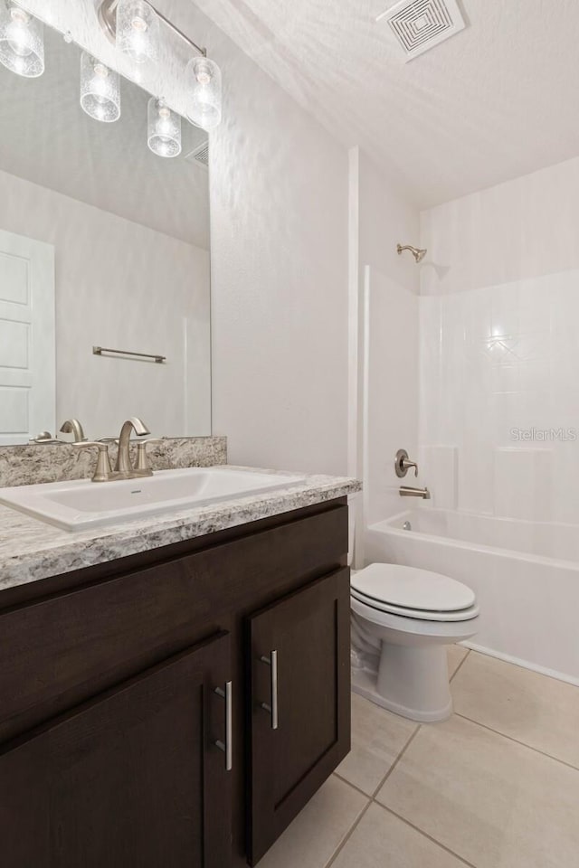 full bathroom featuring bathtub / shower combination, tile patterned flooring, vanity, toilet, and a textured ceiling