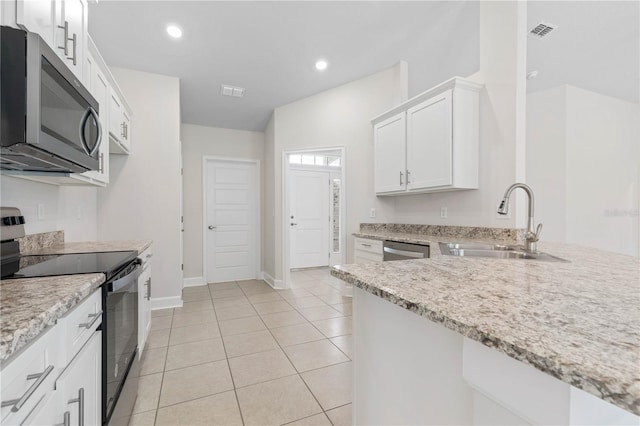 kitchen featuring sink, white cabinetry, light stone counters, light tile patterned floors, and stainless steel appliances