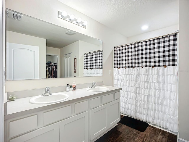 bathroom featuring hardwood / wood-style floors, vanity, and a textured ceiling