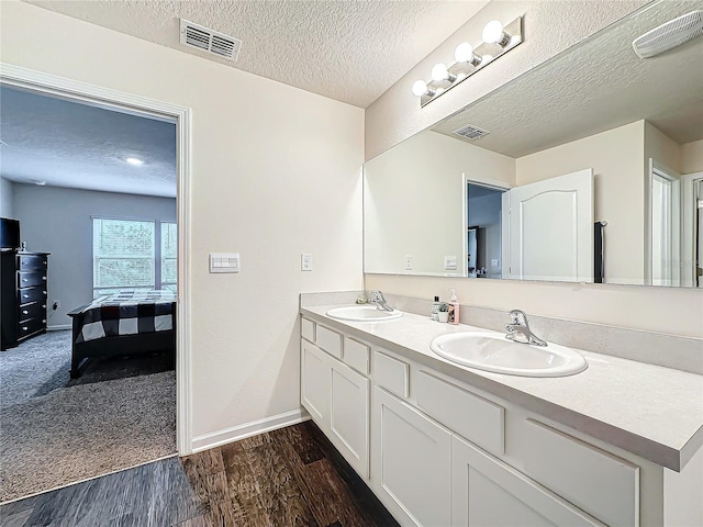 bathroom featuring vanity, hardwood / wood-style floors, and a textured ceiling