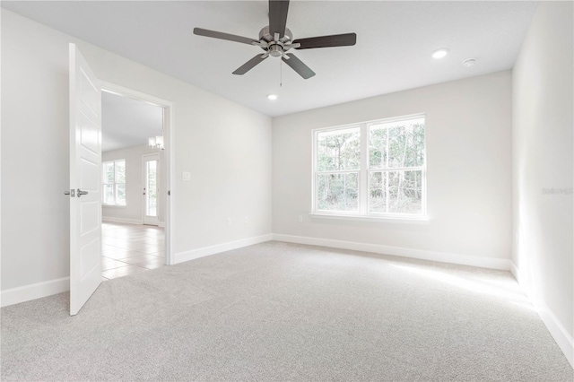 carpeted spare room with ceiling fan