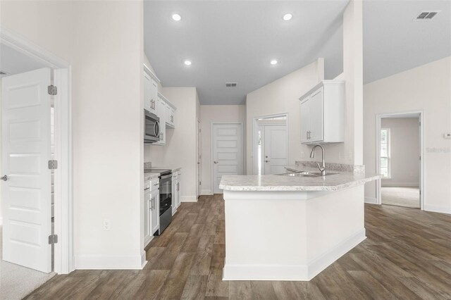 39 Zaun Trl, Palm Coast, FL 32164 - kitchen with appliances with stainless steel finishes, baseboards, a peninsula, a sink, and dark wood finished floors
