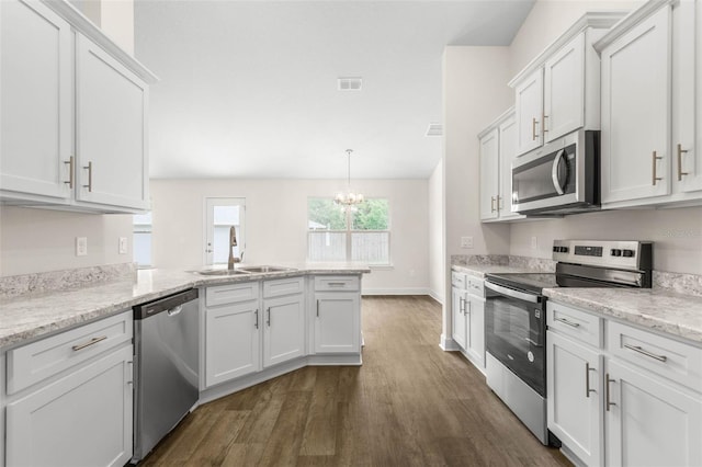 39 Zaun Trl, Palm Coast, FL 32164 - kitchen featuring appliances with stainless steel finishes, a sink, dark wood-style flooring, a peninsula, and white cabinets