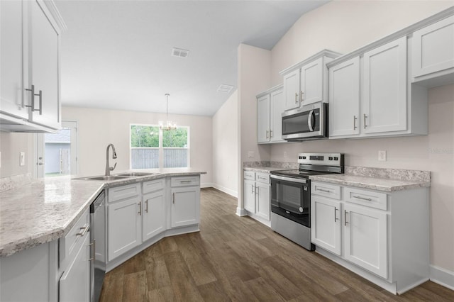 39 Zaun Trl, Palm Coast, FL 32164 - kitchen featuring appliances with stainless steel finishes, a sink, dark wood finished floors, a peninsula, and lofted ceiling