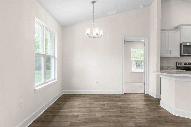 39 Zaun Trl, Palm Coast, FL 32164 - unfurnished dining area with vaulted ceiling, plenty of natural light, a chandelier, and dark wood finished floors