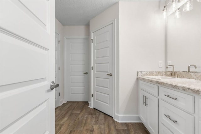 39 Zaun Trl, Palm Coast, FL 32164 - bathroom featuring vanity, wood finished floors, a textured ceiling, and baseboards