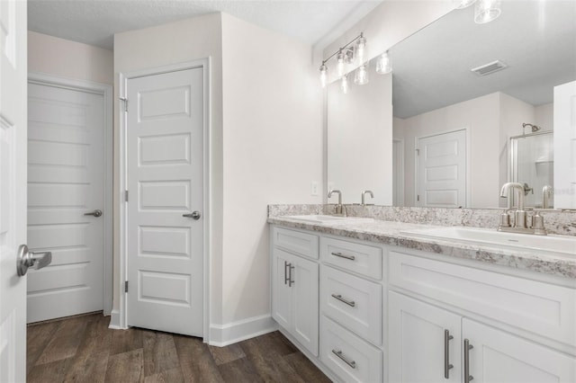 39 Zaun Trl, Palm Coast, FL 32164 - bathroom with double vanity, wood finished floors, a shower with shower door, and baseboards