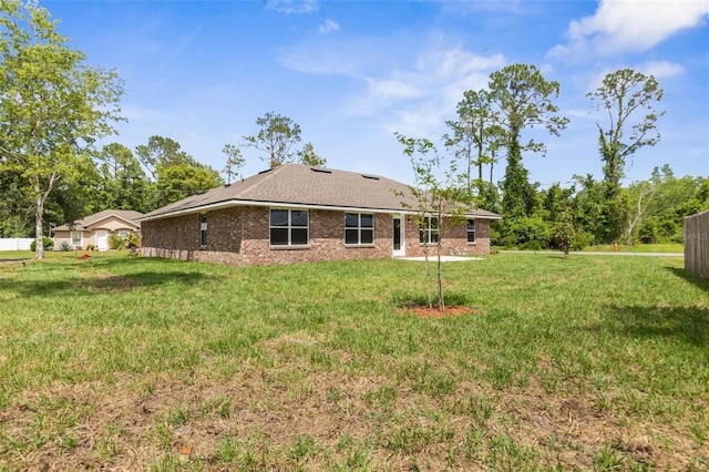 39 Zaun Trl, Palm Coast, FL 32164 - back of house featuring brick siding and a lawn