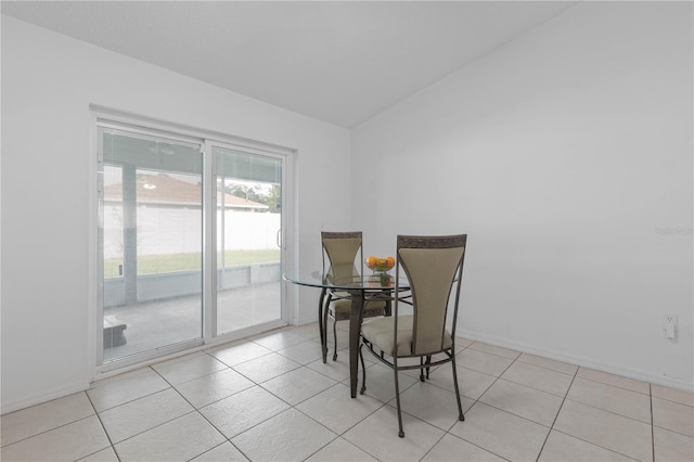 tiled dining space with lofted ceiling