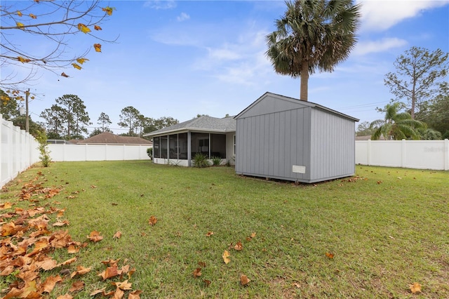 view of yard featuring a sunroom and a storage shed