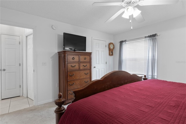 bedroom with a textured ceiling, light colored carpet, and ceiling fan