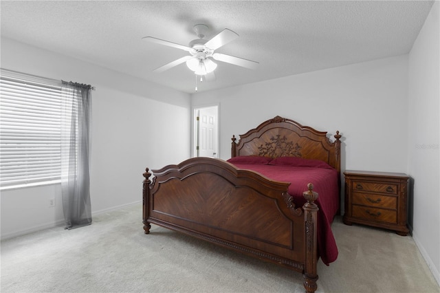 bedroom featuring light carpet, a textured ceiling, and ceiling fan