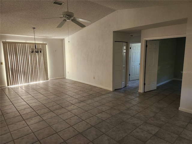 spare room with ceiling fan with notable chandelier and lofted ceiling