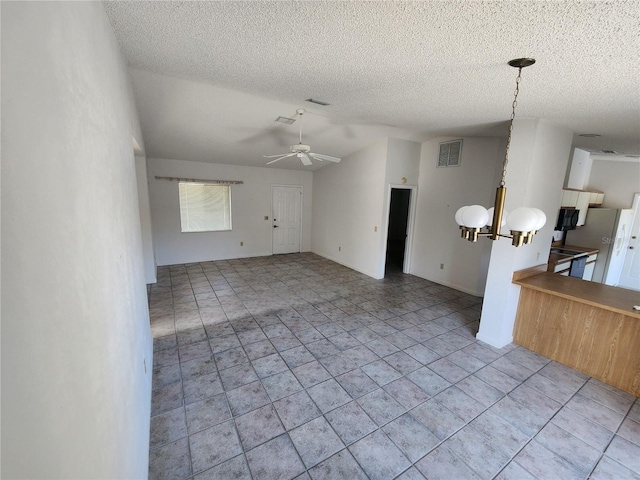 unfurnished living room featuring visible vents, ceiling fan with notable chandelier, a textured ceiling, light tile patterned floors, and lofted ceiling