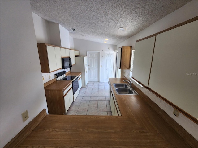 kitchen featuring white appliances, a textured ceiling, sink, light tile patterned floors, and lofted ceiling