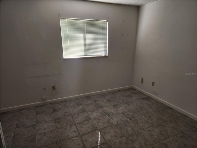 unfurnished room featuring baseboards and a textured ceiling