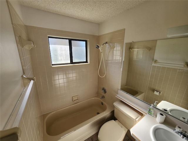 full bath featuring a textured ceiling, a sink, shower / bath combination, tile walls, and toilet