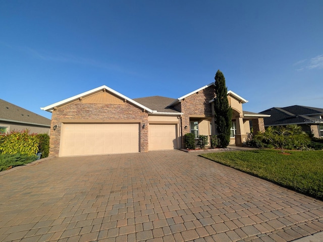 ranch-style home featuring a garage and a front yard