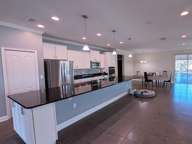 kitchen featuring white cabinetry, pendant lighting, an island with sink, and stainless steel appliances