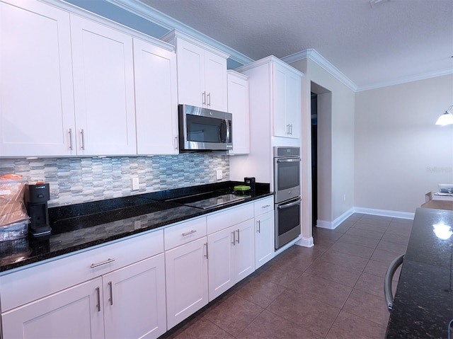 kitchen with backsplash, dark stone counters, white cabinets, crown molding, and appliances with stainless steel finishes