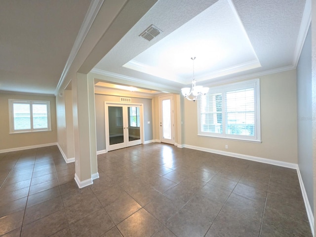 unfurnished room with a healthy amount of sunlight, a raised ceiling, crown molding, and an inviting chandelier