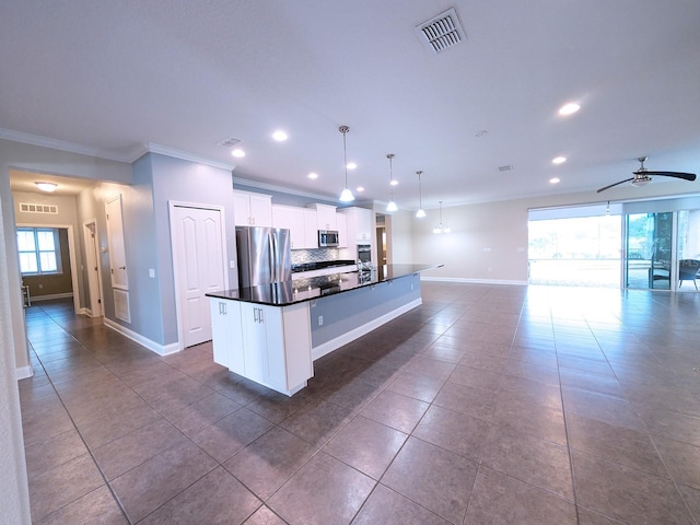 kitchen featuring white cabinets, appliances with stainless steel finishes, a kitchen island with sink, and pendant lighting