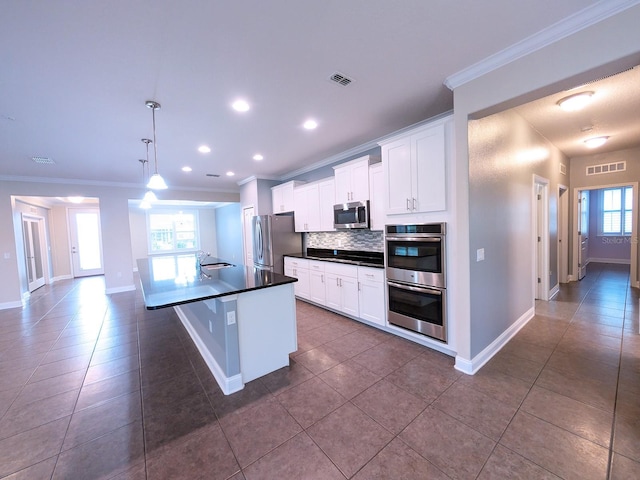 kitchen featuring decorative backsplash, stainless steel appliances, sink, decorative light fixtures, and white cabinetry