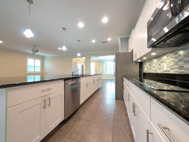 kitchen with pendant lighting, white cabinets, and stainless steel appliances