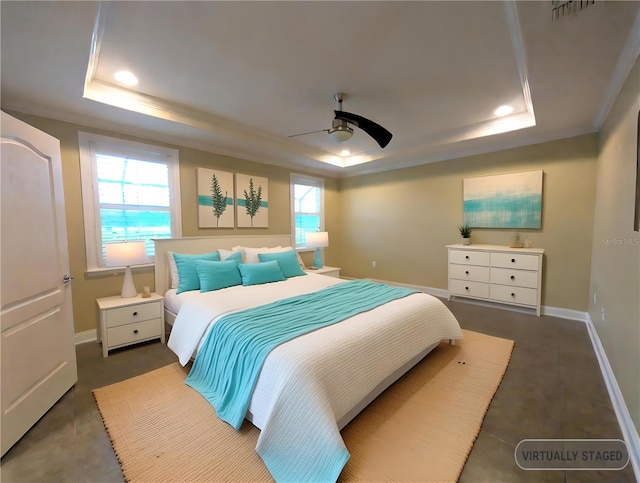 bedroom with multiple windows, a tray ceiling, ceiling fan, and crown molding