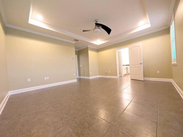 empty room with a raised ceiling, ceiling fan, and crown molding