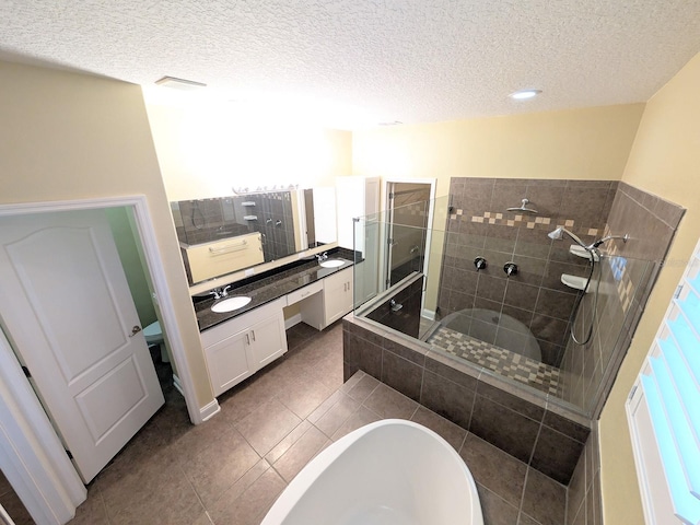 bathroom featuring tile patterned flooring, a textured ceiling, vanity, and independent shower and bath