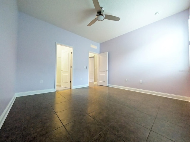 unfurnished bedroom with ceiling fan and dark tile patterned flooring