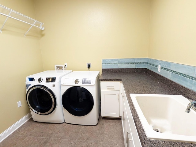 laundry area featuring washer and dryer, cabinets, light tile patterned floors, and sink