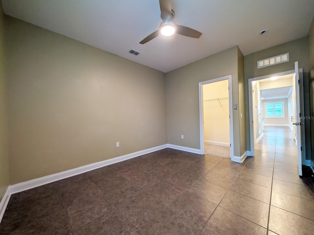 tiled empty room featuring ceiling fan