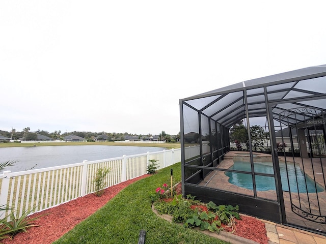 view of dock with a fenced in pool, glass enclosure, and a water view