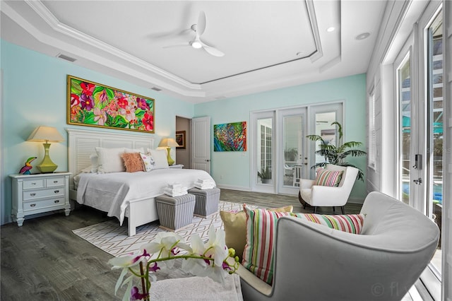 bedroom with access to exterior, multiple windows, a tray ceiling, and french doors