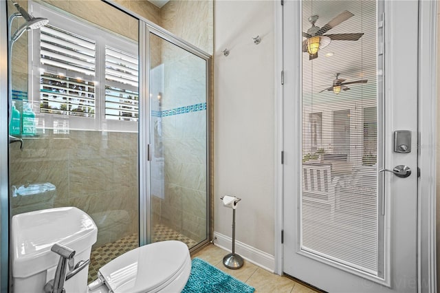 bathroom featuring toilet, ceiling fan, tile patterned floors, and a shower with shower door