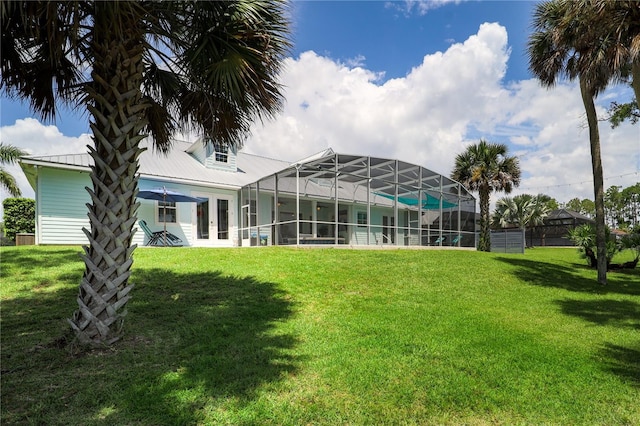 rear view of property with glass enclosure and a yard