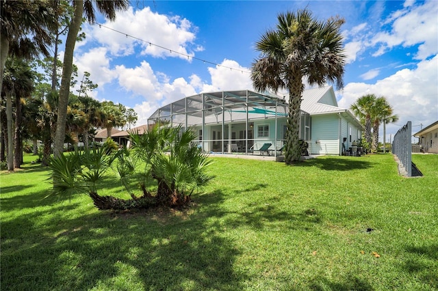 rear view of property featuring a lanai and a lawn