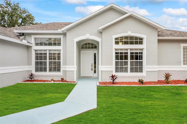 entrance to property featuring a lawn