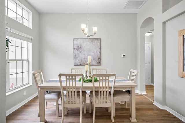 dining area featuring dark hardwood / wood-style flooring and a chandelier