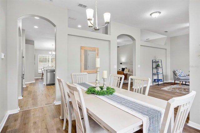 dining room with a notable chandelier and light wood-type flooring