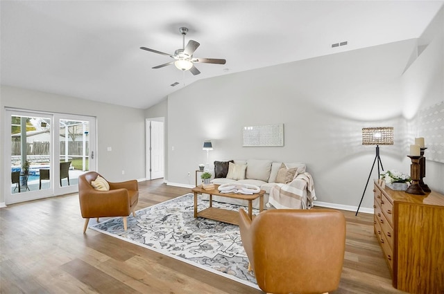 living room with ceiling fan, wood-type flooring, and lofted ceiling