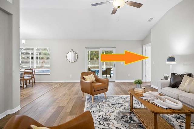 living room with ceiling fan, lofted ceiling, and light hardwood / wood-style flooring